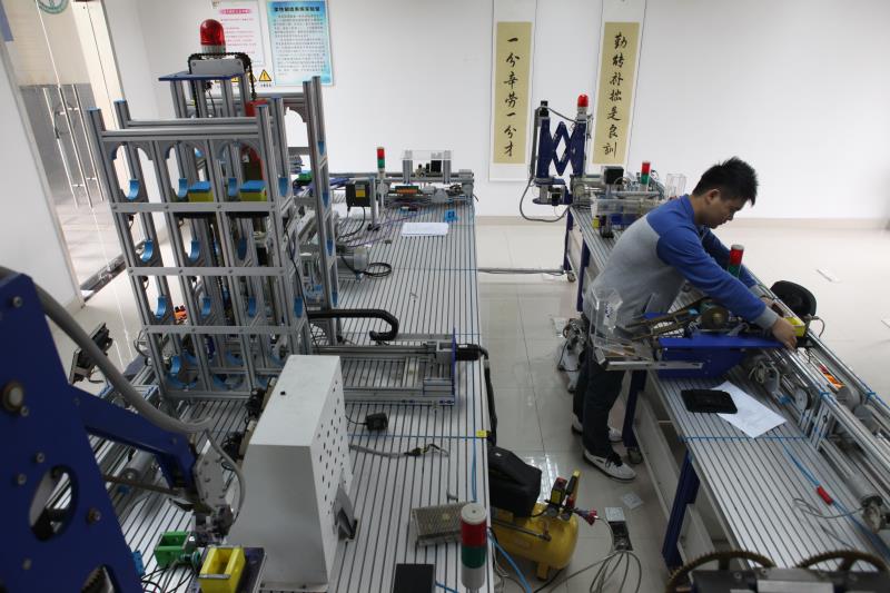 学校与龙头企业合作，引入华为、中兴等企业的知识体系，在校内设立建制班级或开设相关课程。图为学生在先进自动化技术联合示范实验中心学习。